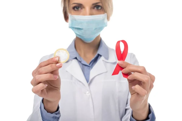 Doctor with aids ribbon and condom — Stock Photo