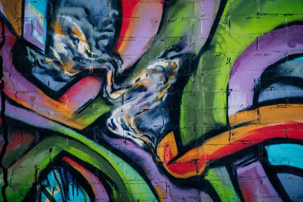 Close up of colorful graffiti on wall in city, street art — Stock Photo