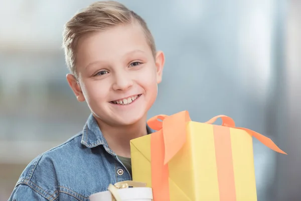 Lächelnder Junge mit gestapelten Kisten im Laden — Stockfoto