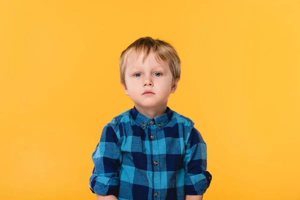 Retrato de niño en camisa mirando a la cámara aislada en amarillo - foto de stock