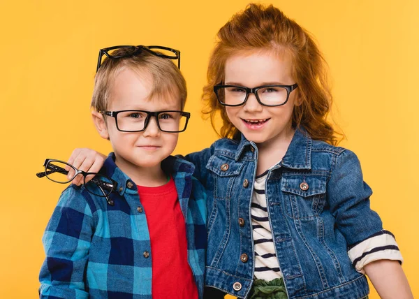 Ritratto di bambini sorridenti in occhiali isolati su giallo — Foto stock