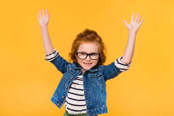 Портрет милої маленької дитини в окулярах з розтягнутими руками ізольовані на жовтому — стокове фото