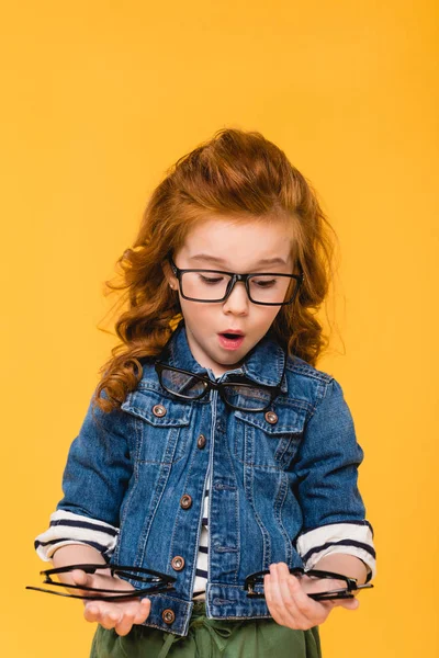 Портрет шокированного ребенка в очках, изолированных на желтом — стоковое фото