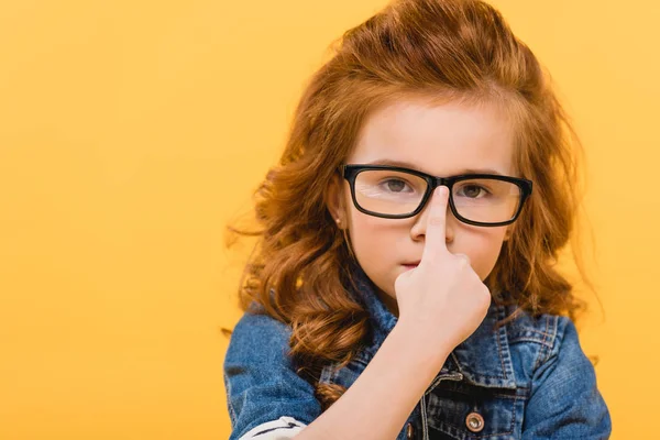 Portrait of cute little kid in eyeglasses isolated on yellow — Stock Photo