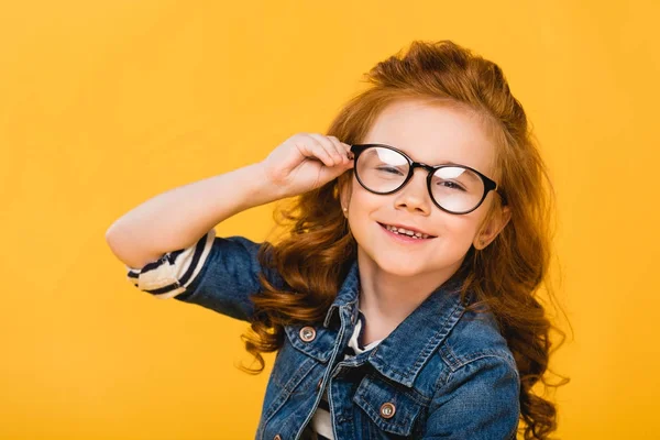 Портрет милого улыбающегося ребенка в очках, изолированных на желтом — стоковое фото
