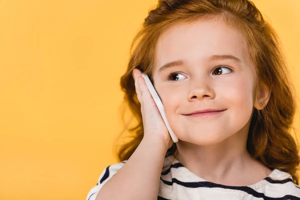 Retrato de niño lindo hablando en el teléfono inteligente aislado en amarillo - foto de stock