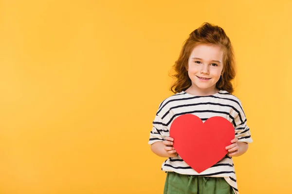 Retrato de niño sonriente con corazón de papel rojo aislado en amarillo, San Valentín concepto de día - foto de stock