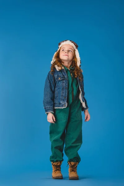 Adorável criança pré-adolescente em traje piloto olhando para longe isolado em azul — Fotografia de Stock