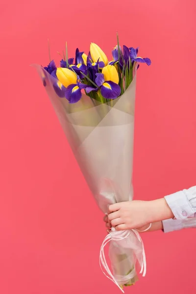 Vue partielle de l'enfant tenant bouquet de fleurs isolé sur rose — Photo de stock