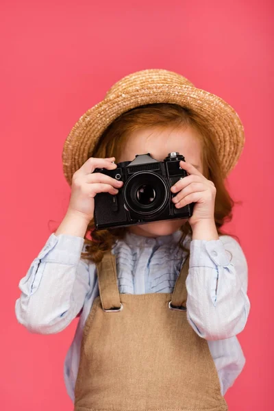 Obscured view of child holding photo camera isolated on pink — Stock Photo