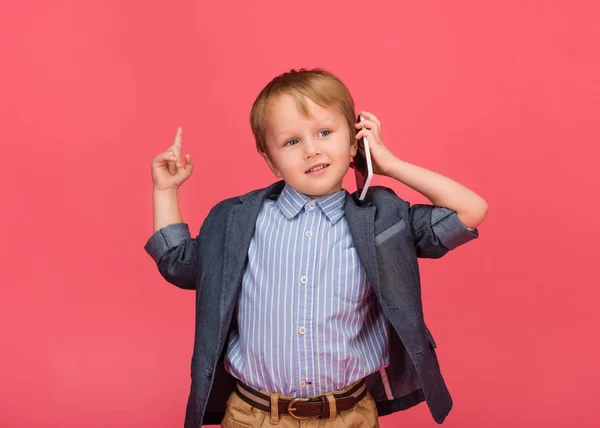 Ritratto di bambino che parla su smartphone isolato su rosa — Foto stock