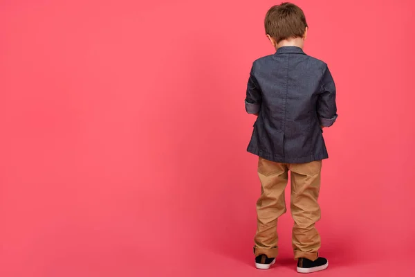 Rückansicht eines Jungen in lässiger Kleidung isoliert auf rosa — Stockfoto