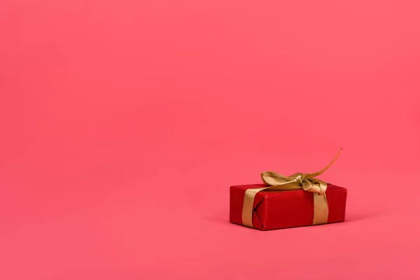 Крупним планом загорнутий подарунок зі стрічкою ізольований на рожевому — стокове фото