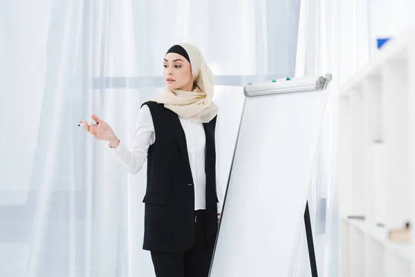 Árabe empresária no formal desgaste e hijab de pé no branco bordo no escritório — Fotografia de Stock