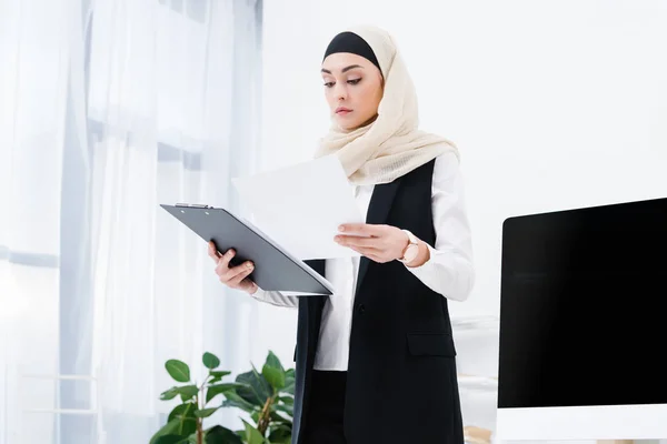 Портрет концентрованої арабської бізнес-леді, що робить документи в офісі — стокове фото