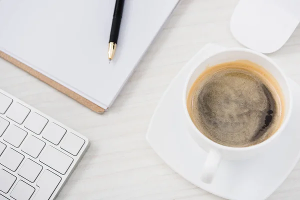 Close up view of arranged computer keyboard, mouse, cup of coffee and papers on table — Stock Photo