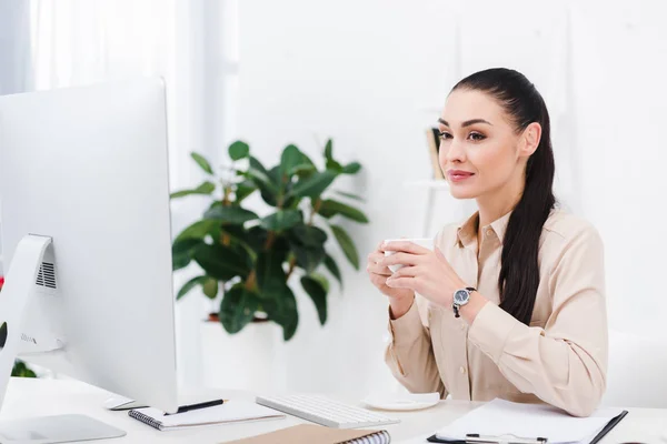 Retrato de mujer de negocios con taza de café en el lugar de trabajo en la oficina — Stock Photo