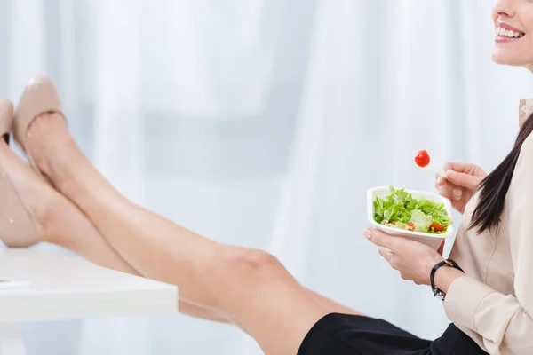 Teilansicht einer Geschäftsfrau mit Essen zum Mitnehmen am Arbeitsplatz im Büro — Stockfoto