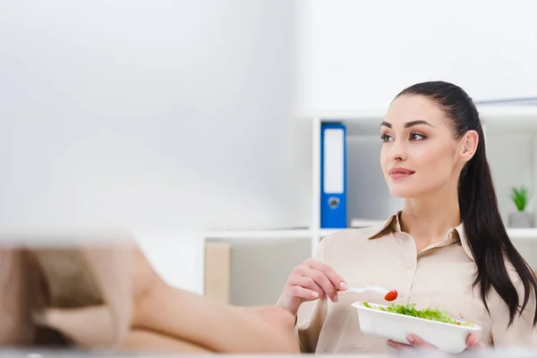Attractive businesswoman with take away food at workplace in office — Stock Photo