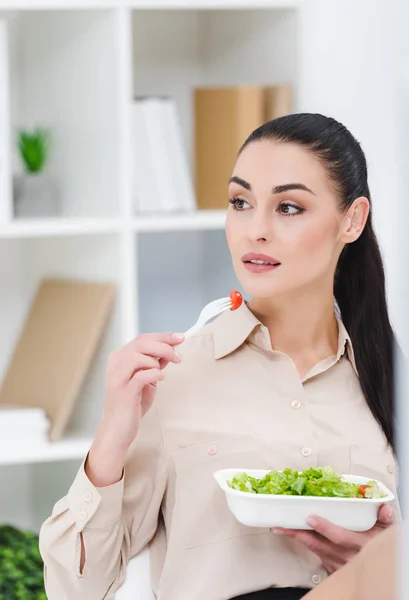 Portrait of businesswoman eating take away salad for lunch in office — Stock Photo