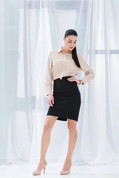 Attractive and stylish businesswoman akimbo in formal wear in office — Stock Photo