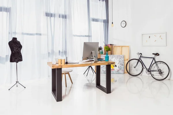 Amplia oficina en casa con mesa de trabajo y bicicleta — Stock Photo