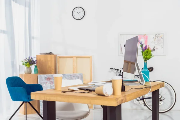 Tazas de papel en la mesa del espacio de trabajo con ordenador — Stock Photo