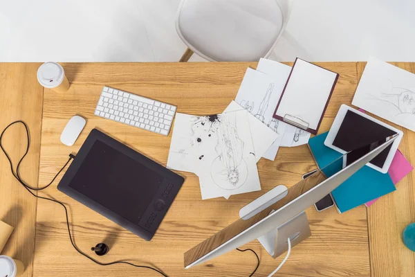 Top view of designer workplace with fashion illustrations and computer — Stock Photo