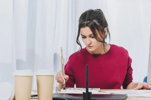 Attractive young girl working on illustrations in home office — Stock Photo