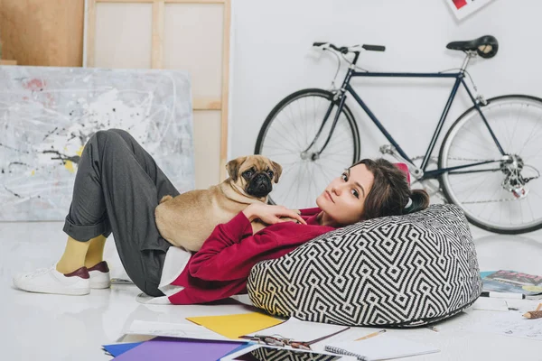 Jovem deitada no chão com pug — Fotografia de Stock