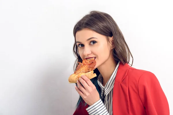 Jovem mulher comendo pizza no fundo branco — Fotografia de Stock