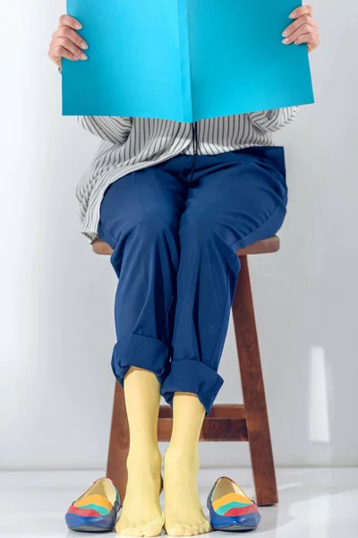 Vista da vicino della donna seduta sulla sedia e libro di lettura — Foto stock