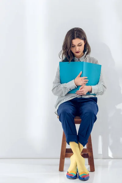 Junge Frau sitzt auf Stuhl und liest Buch — Stockfoto
