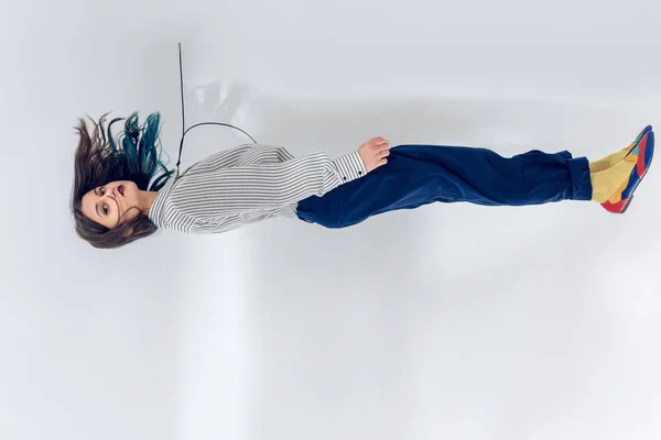 Mujer joven levitando sobre fondo blanco de la pared - foto de stock