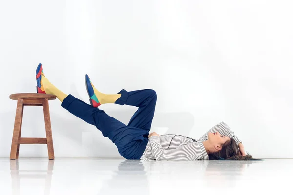 Rapariga atraente descansando no chão sobre fundo branco — Fotografia de Stock