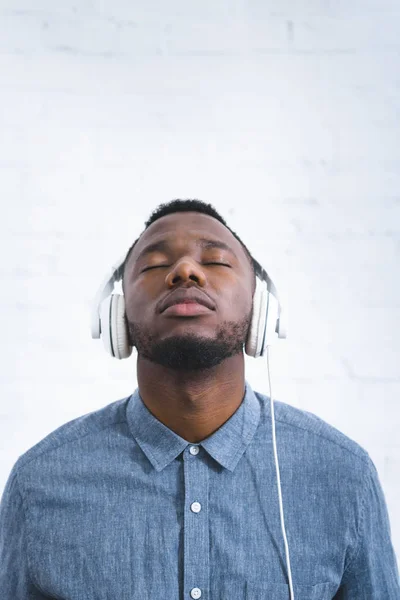 Jovem ouvindo música em fones de ouvido — Fotografia de Stock