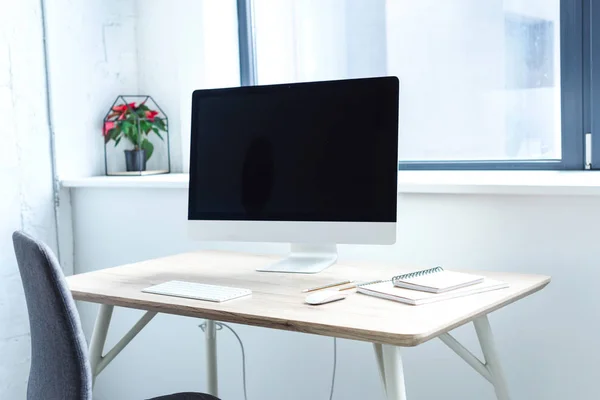 Pantalla en blanco del ordenador en la mesa de trabajo - foto de stock