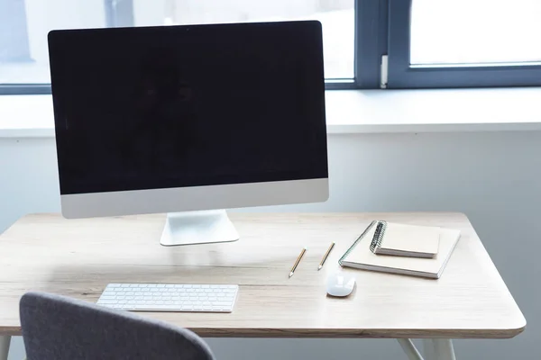 Computer with blank monitor on working table — Stock Photo