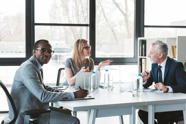 Professionnels multiethniques hommes d'affaires ayant une conversation lors d'une réunion d'affaires — Photo de stock