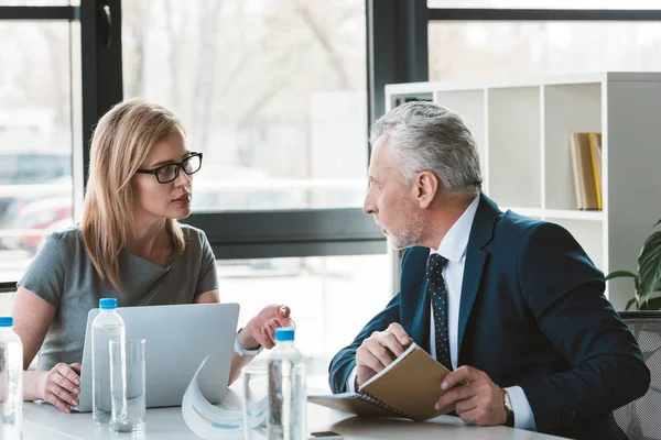 Ernsthafte professionelle Geschäftsleute, die sich gegenseitig anschauen und im Büro diskutieren — Stockfoto