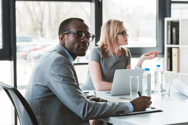 Multiethnic businessman and businesswoman working at business meeting in office — Stock Photo