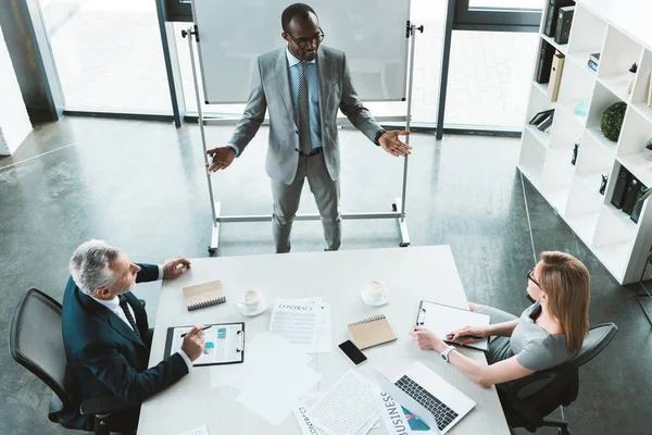 High-Winkel-Ansicht von professionellen multiethnischen Geschäftsleuten, die sich während eines Geschäftstreffens unterhalten — Stockfoto