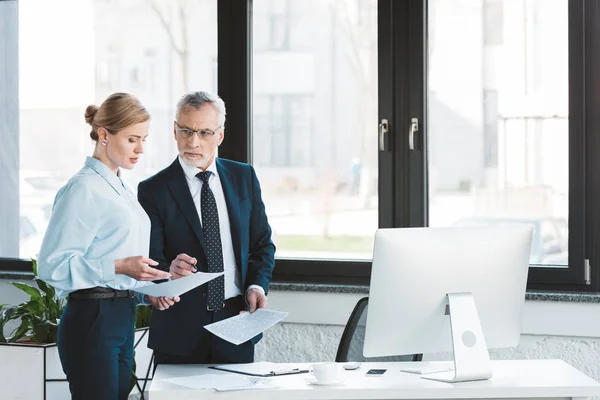 Two serious business colleagues discussing papers in office — Stock Photo