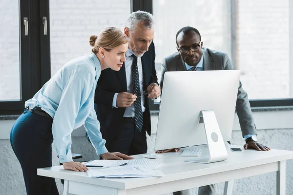 Multiethnische Geschäftskollegen schauen im Büro auf Desktop-Computer — Stockfoto