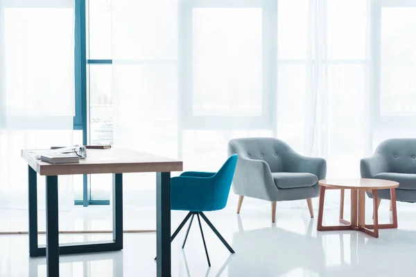 Table en bois et fauteuils confortables vides dans l'intérieur de bureau moderne — Photo de stock