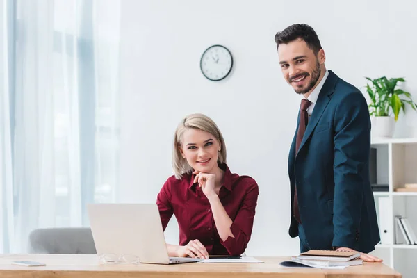 Belos jovens empresários trabalhando juntos e sorrindo para a câmera — Fotografia de Stock