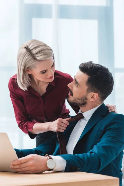 Sinnliche junge Geschäftsleute, die einander anschauen und im Büro flirten — Stockfoto