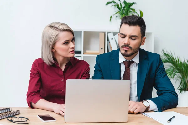 Jeunes gens d'affaires travaillant ensemble et utilisant un ordinateur portable au bureau — Photo de stock