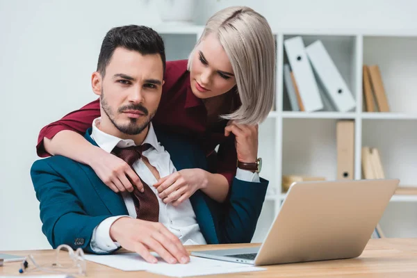 Beautiful young businesswoman flirting with handsome businessman in office — Stock Photo