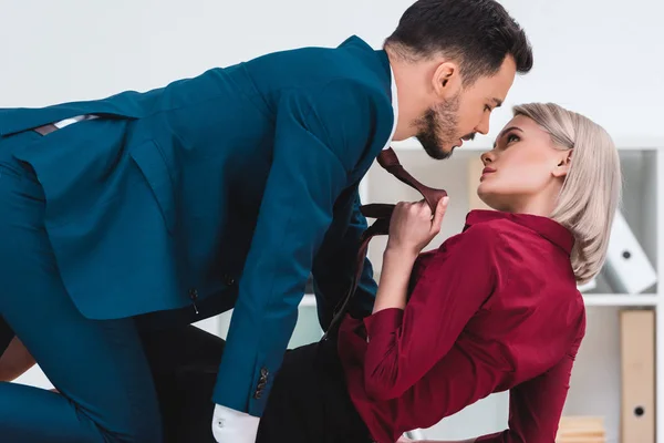 Seductive young couple of business people looking at each other in foreplay at workplace — Stock Photo